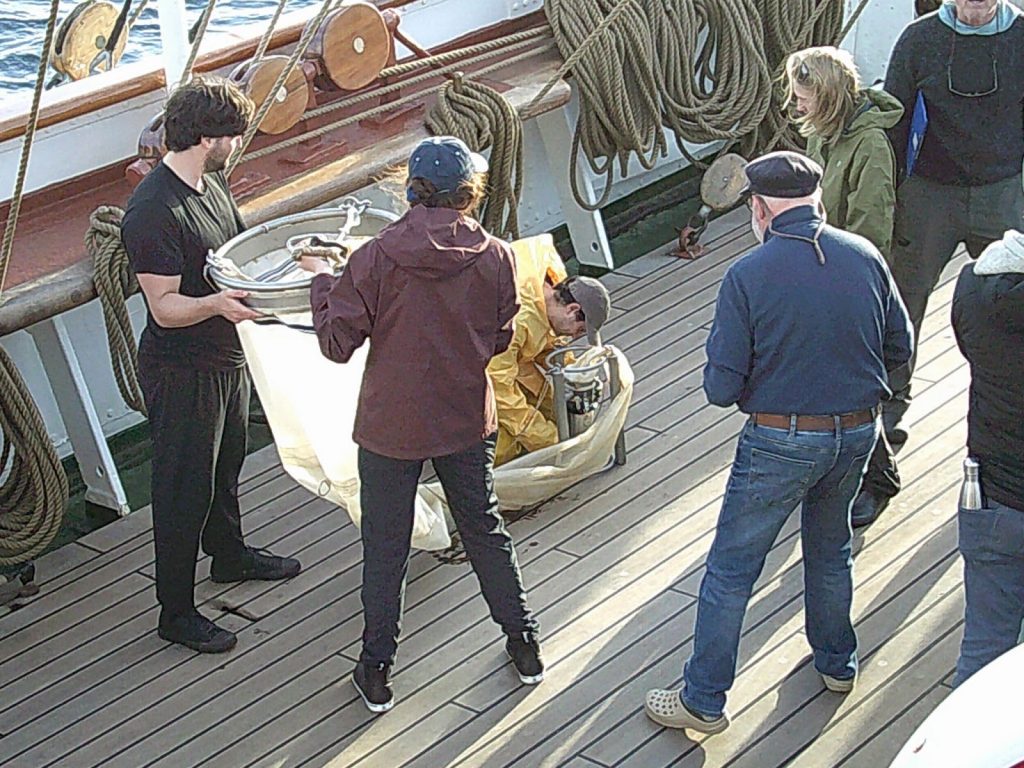 three scientists measuring on the ship